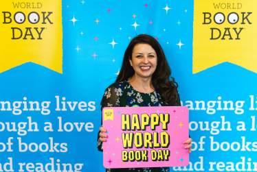 Joy on World Book Day holding sign.